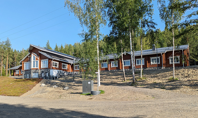 Leirikeskuksen puinen päärakennus rantatöyräällä.